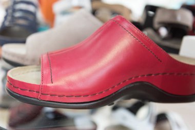 Mağaza vitrininde rahat ortopedik ayakkabılar var. Modern tarz kırmızı deri ayakkabılar. Ayaklarına bakıyorum. Düz taban önleme ve tedavi