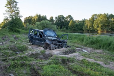 Bozuk araba, yolda terk edilmiş. Çalıntı araba. Arabadan tekerlekler çıkarılmış, her şey kırılmış ve bükülmüş. Çalıntı arabadan kurtuluyorum.