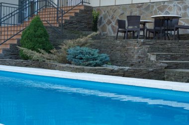 Mavi suyu olan havuz. Otelin avlusunda yüzme havuzu. Peyzaj