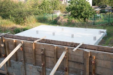 İnşaat alanı. Kereste işi beton dökmek için hazırlandı. Metal parçalar da görülebilir. Özel bir ev inşa etme süreci