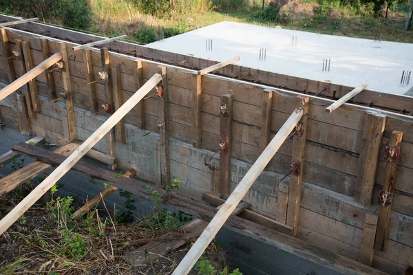 Lugar de construcción. El encofrado de madera está preparado para verter hormigón. Los accesorios de metal también son visibles. El proceso de construcción de una casa privada — Foto de Stock