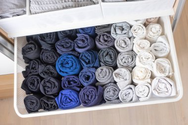 Gardıropta yer düzenleme kavramı. Koyu ve açık renkli giysiler güzelce asılır ve dolaba saklanır..