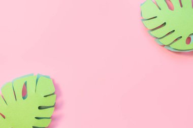 Kağıt canavarı pembe arka planda yapraklar bırakır. Yaratıcı kağıt sanatı. Arkaplan parlak yaz görüntüsü.