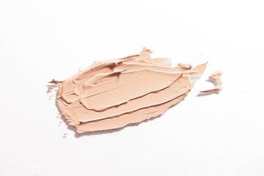 Smear of foundation isolated on white background. The concept of decorative cosmetics, make-up. Advertising macro photography.	