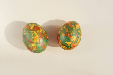 Easter eggs painted in trendy colors of green, yellow and red. Mosaic pattern. Light background, top view, myimalism, copy space.
