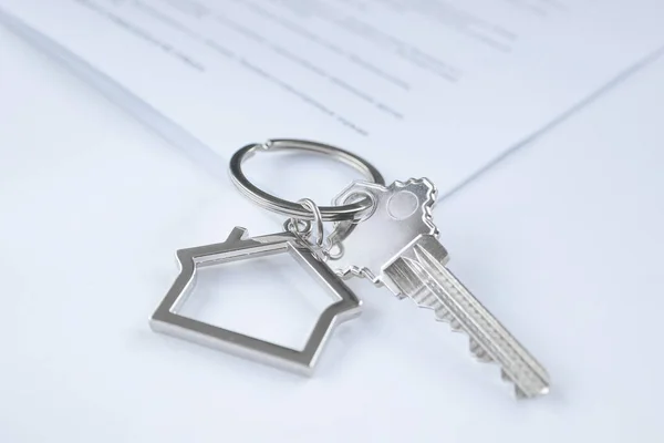 钥匙的特写 钥匙串在房子的形状上 文件在后面 购买和担保房地产 抵押贷款的概念 复制空间 — 图库照片