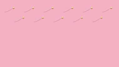 Pembe arka planda sarı tüylü diş fırçaları. 