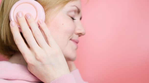 Biała Dziewczyna Różowej Bluzie Różowymi Słuchawkami Tle Podobnym Tonem Koncepcja — Wideo stockowe