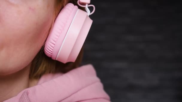 Biała Dziewczyna Różowej Bluzie Różowymi Słuchawkami Tle Podobnym Tonem Koncepcja — Wideo stockowe