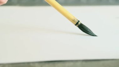 Çin sanat fırçası mürekkebi beyaz kağıt üzerinde. Resim yapma, resim öğretme araçları konsepti. Makro fotoğraf.