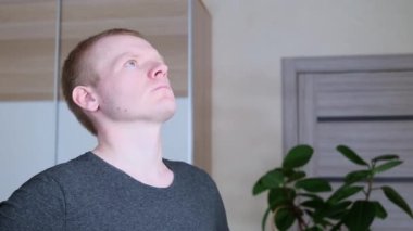 Eğitimden önce genç, beyaz, sarışın erkek boynunu yoğuruyor. Evde spor konsepti, tecrit.