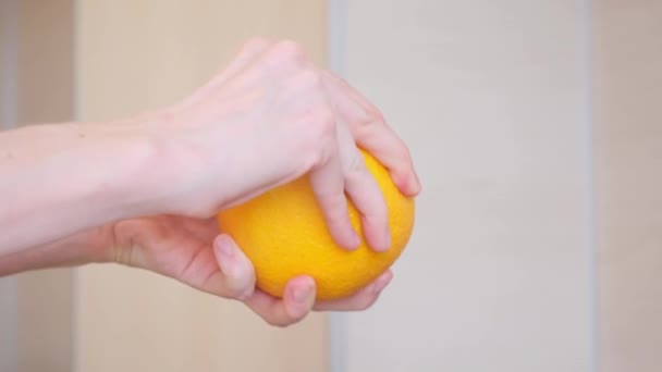 Kvinnliga händer skalar en apelsin. Begreppet frukt, vitamin C — Stockvideo
