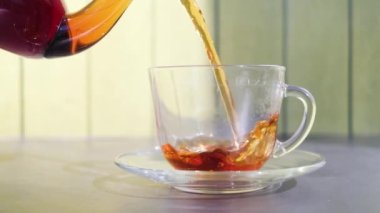 Taze aromatik bitkisel çay şeffaf bir fincana dökülür. Sıcak sıcak vitamin ve sağlıklı içecekler konsepti.