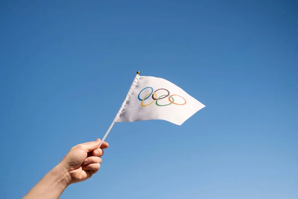 Маленький Руках Олимпийский Флаг Развевается Фоне Голубого Безоблачного Неба Концепция — стоковое фото