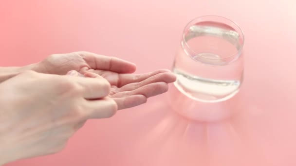 Vitaminer Gul Färg Hand Rosa Bakgrund Bakom Ett Glas Vatten — Stockvideo