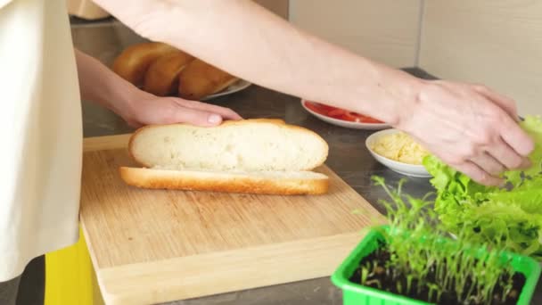 Mãos Estendem Folhas Alface Pão Sanduíche Uma Tábua Corte Madeira — Vídeo de Stock