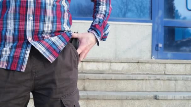 Seorang Pria Dengan Kemeja Merah Kotak Kotak Biru Mengambil Dompet — Stok Video
