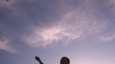 Mavi uçurtma günbatımında gökyüzünde süzülüyor. Adam uçurtmayı yönetiyor. Özgürlük kavramı, yaz hobileri, doğada eğlence. Minimalizm, metin için alan, mavinin tonları. Siluet