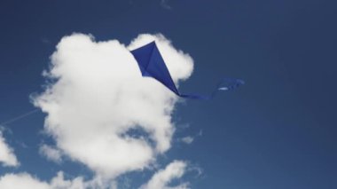 Mavi bir uçurtma gökyüzünde süzülüyor. Özgürlük kavramı, yaz hobileri, doğada eğlence. Minimalizm, metin için alan, mavinin tonları.