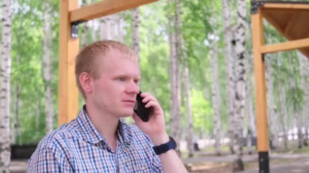 Jonge Blonde Man Een Geruit Shirt Met Een Mobiele Telefoon — Stockvideo