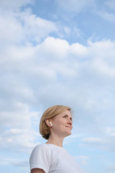 Young Caucasian Girl White Shirt Headphones Stands Background Blue Sky — 스톡 사진