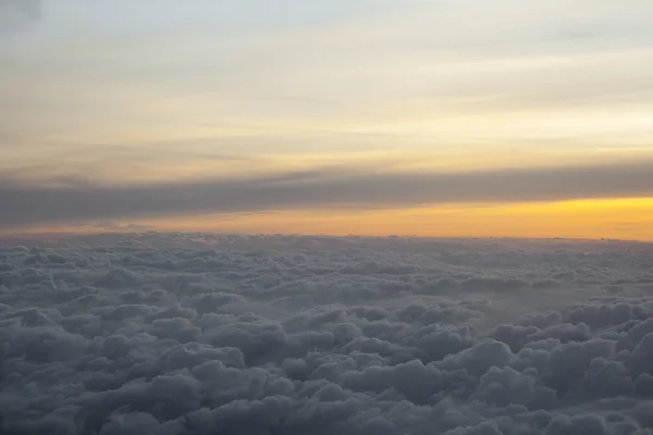 Au-dessus des nuages avec une belle lumière du coucher du soleil — Photo