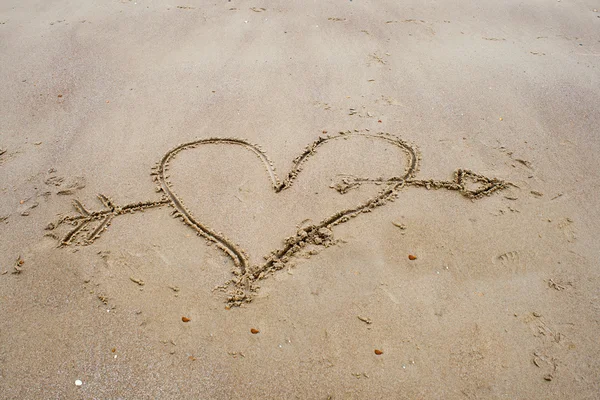 Rita ett hjärta i sanden på stranden — Stockfoto