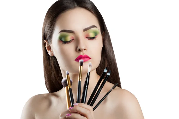 Joven chica hermosa con maquillaje brillante. Una mujer sostiene un cepillo de maquillaje profesional —  Fotos de Stock