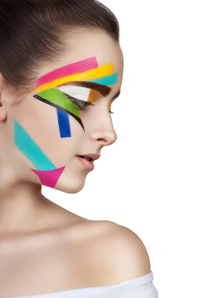 Teen flicka med färgade ränder i ansiktet. Ljusa make-up konst. — Stockfoto