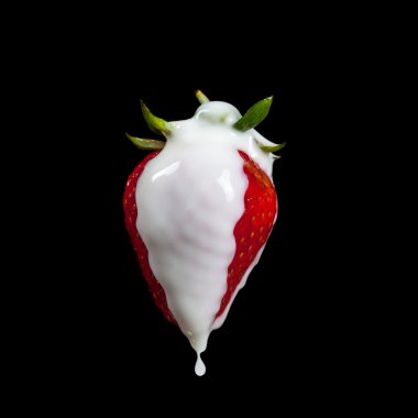 Çilek yapımı bir sıçrama. Siyah arka plan üzerine izole. Makro fotoğraf bir çilekli süt, su sıçramalarına ve damla.