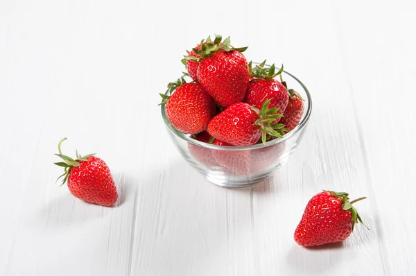 Red fresh strawberry in a bowl on white wooden background — Stock Photo, Image
