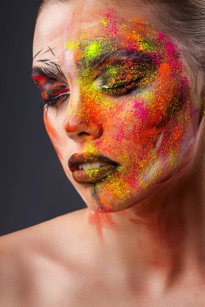 Güzellik moda kız yakın çekim portresi. parlak yaratıcı makyaj. Yüz modeli renkli toz serpilir — Stok fotoğraf