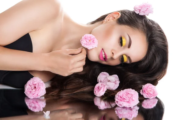 Young beautiful woman is lying near the mirror with its reflection. beauty fashion portrait of a girl with roses — Stock Photo, Image