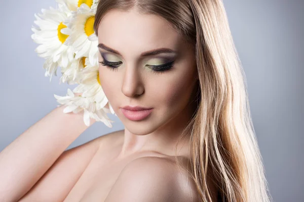 Portrait of a young attractive girl with a beautiful make-up and daisies. — Stock Photo, Image