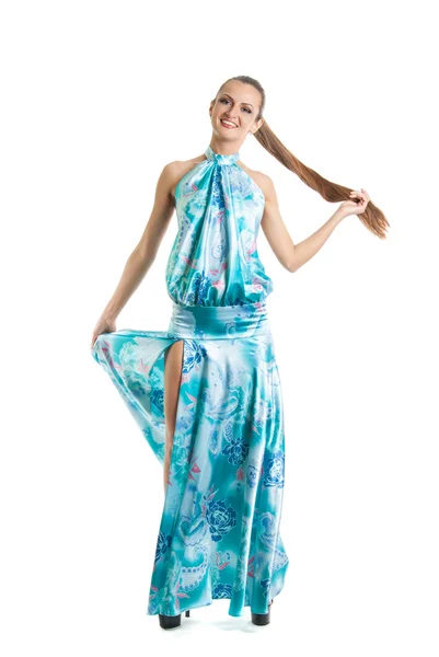 Modeporträt eines jungen hübschen Mädchens in einem blauen Kleid. Sommerhelles Kleid, das im Wind flattert, glatt gekämmtes Haar, nettes Lächeln. — Stockfoto