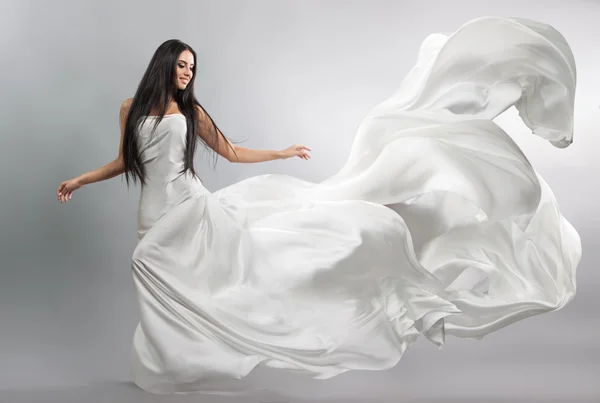 美丽的年轻女孩在飞行白色连衣裙。流动的织物。光白布飞在风中 — 图库照片