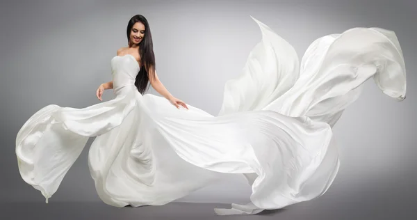 Menina bonita em vestido branco voador. Tecido a fluir. Pano branco claro voando no vento — Fotografia de Stock