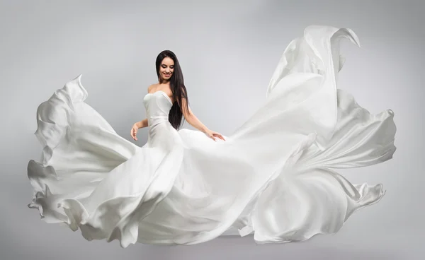 Menina bonita em vestido branco voador. Tecido a fluir. Pano branco claro voando no vento — Fotografia de Stock