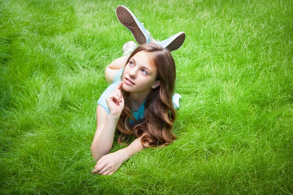 Pretty dospívající dívka ležící na trávě. smích, radost, pozitivní lidské emoce — Stock fotografie