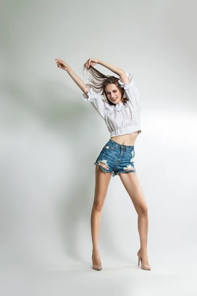 Joven hermosa chica en pantalones cortos y blusa posando en el estudio —  Fotos de Stock