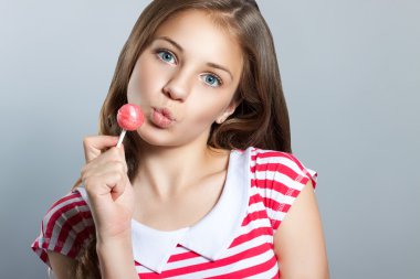 şeker ile sevimli kız şeker yemek. Elinde lolipop olan kız..