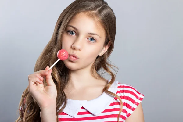 Mignonne fille avec des bonbons manger des bonbons. La fille avec une sucette dans les mains . — Photo