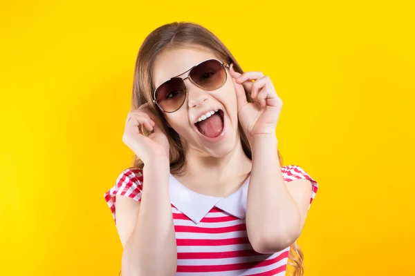 Mooi meisje in zonnebril poseren op een gele achtergrond. Heldere stockfoto's. Positieve menselijke emoties — Stockfoto