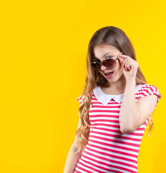 Ładna dziewczyna w okulary stwarzające na żółtym tle. Bright Zdjęcia stockowe. Pozytywne ludzkie emocje — Zdjęcie stockowe