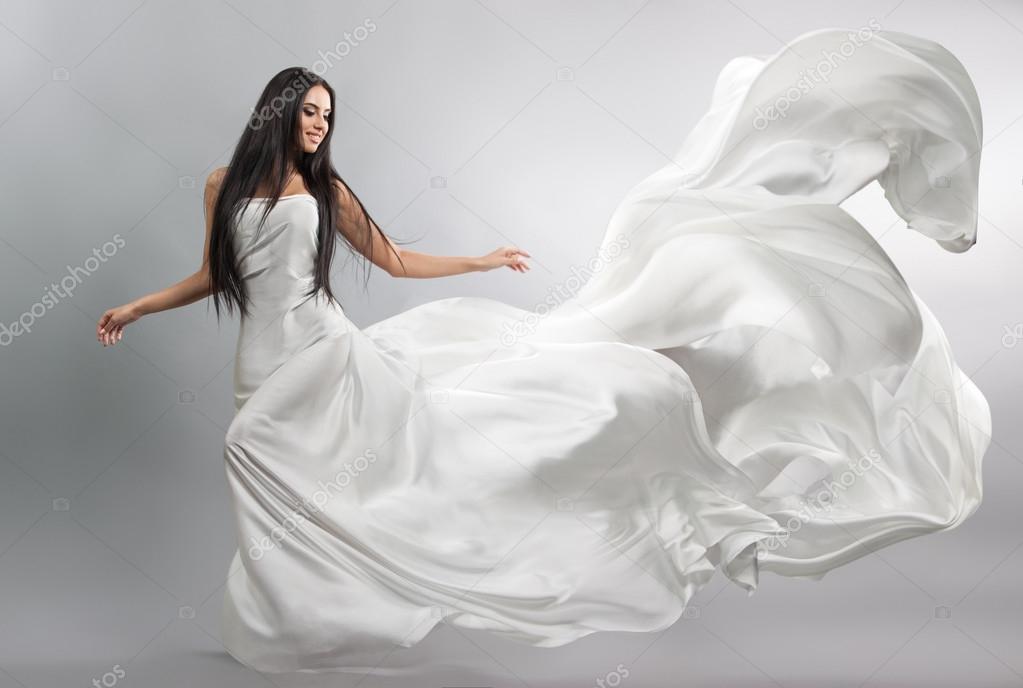 Beautiful young girl in flying white dress. Flowing fabric. Light white ...