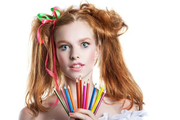 Porträt eines schönen jungen Mädchens mit Buntstiften in der Hand. Mädchen mit kreativer Frisur und Make-up mit Bleistiften. — Stockfoto