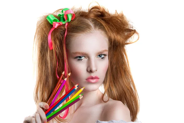 Porträt eines schönen jungen Mädchens mit Buntstiften in der Hand. Mädchen mit kreativer Frisur und Make-up mit Bleistiften. — Stockfoto