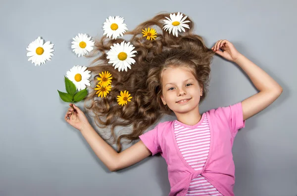 Girl lying with flowers in her hair — Stock Photo, Image