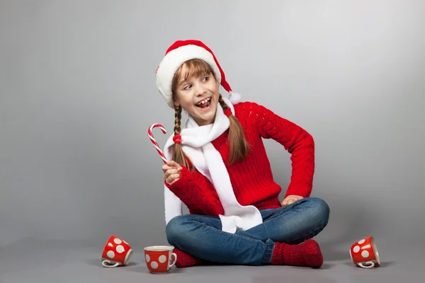 Menina no chapéu de Papai Noel com uma xícara — Fotografia de Stock