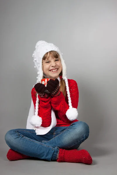 Menina no chapéu de Papai Noel com uma xícara — Fotografia de Stock